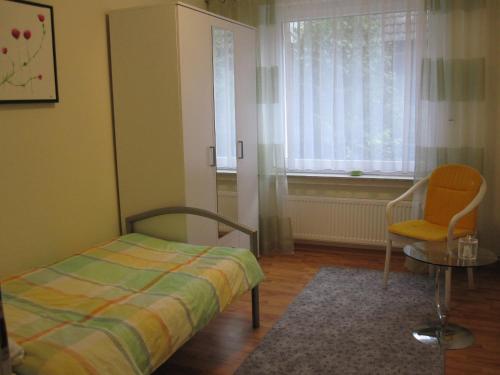 - une chambre avec un lit, une chaise et une fenêtre dans l'établissement Ferienwohnung Bea in Rheine, à Rheine