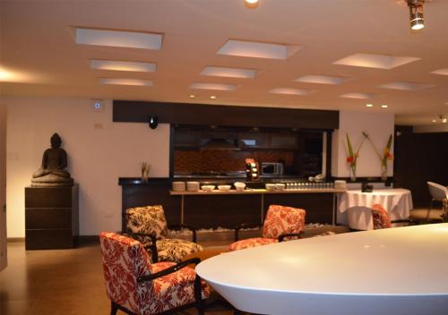 a room with a table and chairs and a kitchen at San Simon Hotel Pereira By Soratama in Pereira