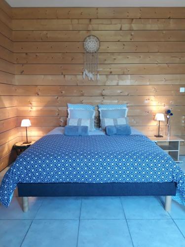 a bedroom with a large bed with a wooden wall at Gite Aux Lauriers in Lacroix-sur-Meuse