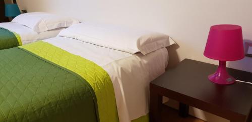 a bedroom with a bed and a table with a lamp at Casa Lady in Garda