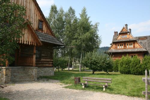a wooden building with a bench in front of it at Polana Sosny in Niedzica Zamek