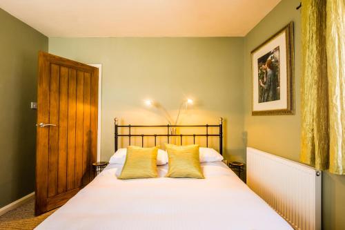 a bedroom with a large white bed with yellow pillows at The Corner House in Whitby