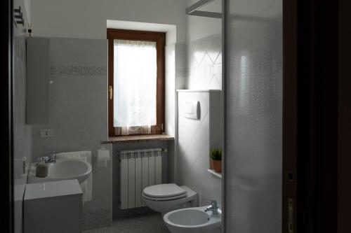 ein weißes Bad mit einem WC und einem Waschbecken in der Unterkunft La Bouganville di Sante e Rosa in Manoppello