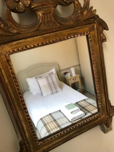 a mirror reflecting a bed with a book on it at Galtres Lodge Hotel & Forest Restaurant in York