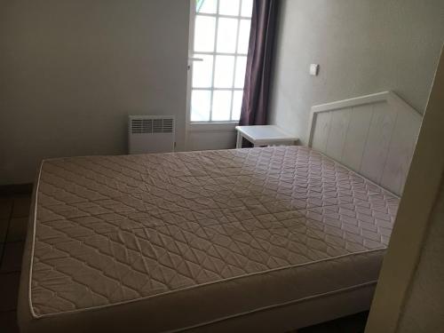 un grand lit dans une chambre avec une fenêtre dans l'établissement Domaine de Bordaberry, à Urrugne