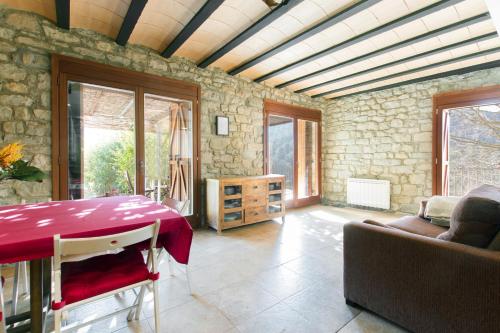 ein Wohnzimmer mit einem Tisch und einem Sofa in der Unterkunft Masia el Prat in El Pont de Vilomara