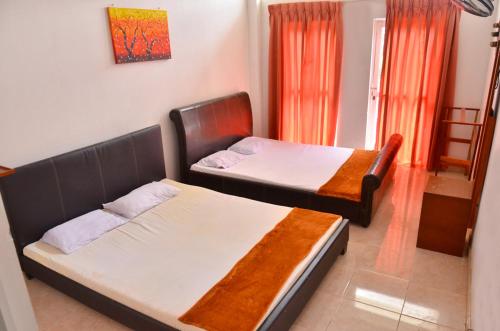 - une chambre avec 2 lits et une fenêtre dans l'établissement Victorian Guest, à Bandarawela