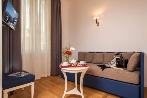 a living room with a couch and a table at Floris Hotel in Rome
