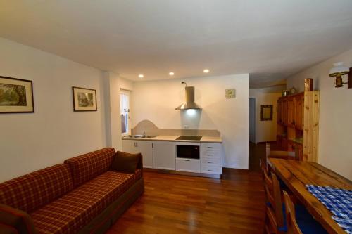 ein Wohnzimmer mit einem Sofa und einer Küche in der Unterkunft MIRADOLO in Madonna di Campiglio
