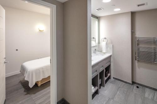 a bathroom with a sink and a mirror and a bed at YO1 Longevity & Health Resorts, Catskills in Monticello