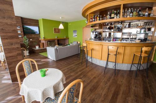a restaurant with a bar with a table and chairs at Hotel & Residence Montana in Fai della Paganella
