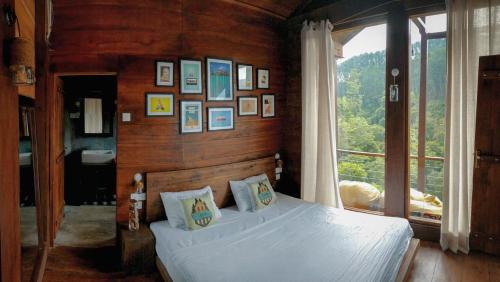 a bedroom with a bed and a large window at The Cabin Ella in Ella