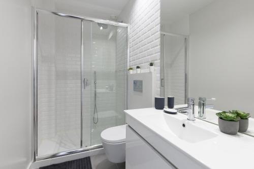 a white bathroom with a shower and a toilet at Host Wise - Charming Flat with Netflix - River View in Porto