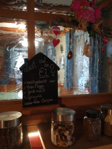 a chalkboard sign sitting on a counter with jars of food at Pension Landhaus Ingrid B&B in Loich