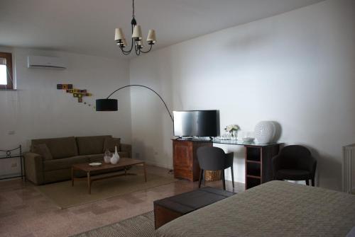 un soggiorno con un divano e una TV di Santo Mercurio Country House a Pisciotta