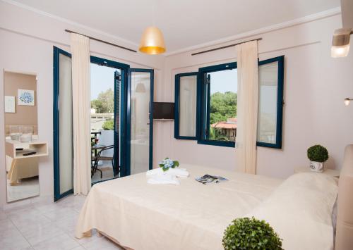 a bedroom with a large white bed and windows at Crete Residence Villas in Panormos Rethymno