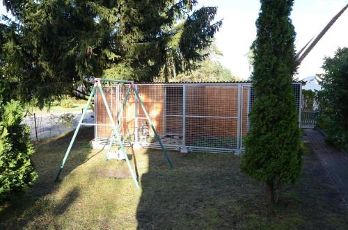 a swing set in a yard next to a fence at FH Hannahliese_WEND in Ostseebad Karlshagen