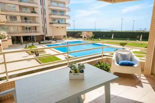 an apartment balcony with a table and a swimming pool at BARRAMARES 1 in Furadouro
