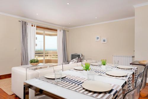 a white dining room with a table and chairs at BARRAMARES 1 in Furadouro