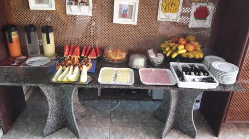 a table with a bunch of food on it at Pousada Girassol in Rio das Ostras