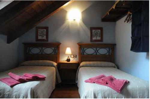 two beds in a room with pink towels on them at Borda Felices in Broto