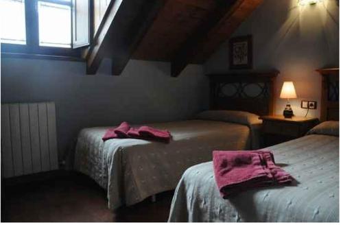 a bedroom with two beds with pink towels on them at Borda Felices in Broto