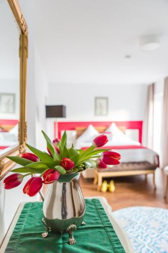 a vase with flowers on a table in a bedroom at Hotel Vorderburg in Schlitz