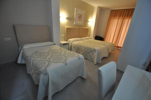 a hotel room with two beds and a window at Hotel Goya in Almuñécar