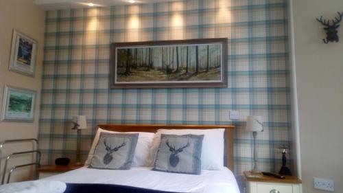 a bedroom with a bed with a painting on the wall at Invergarry Room Only Guest House For Adults in Windermere