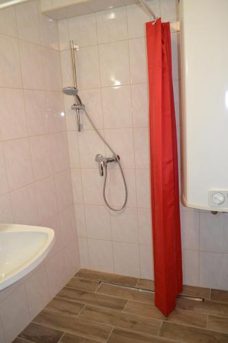 a shower with a red curtain in a bathroom at Apartment Holiday Lungötz in Annaberg im Lammertal