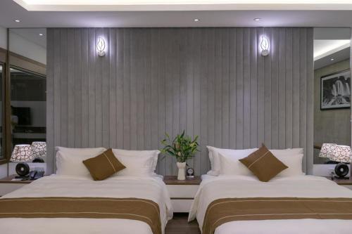 two beds in a hotel room with white pillows at KP Hotel in Can Tho