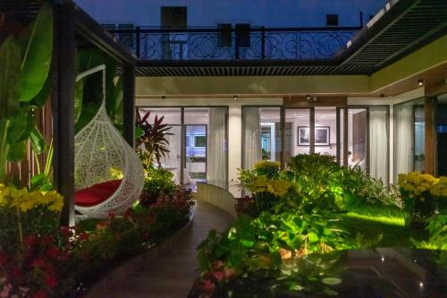 arium of a building with a hammock in a garden at KP Hotel in Can Tho