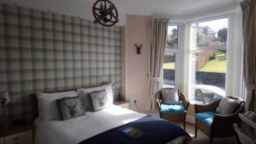 a bedroom with a bed and a large window at Invergarry Room Only Guest House For Adults in Windermere