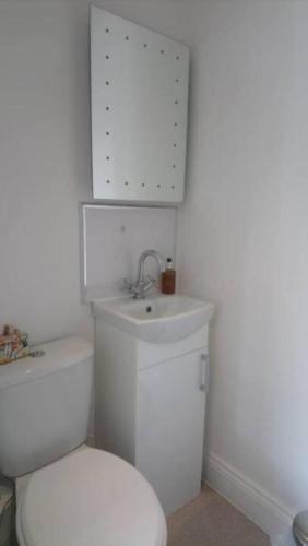 a white bathroom with a toilet and a sink at Invergarry Room Only Guest House For Adults in Windermere