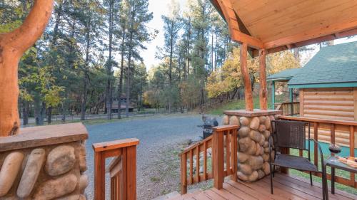 a porch of a cabin with a grill at Upper Canyon Inn & Cabins in Ruidoso