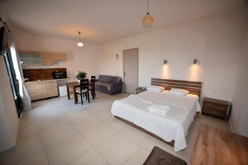 a bedroom with a large bed and a kitchen at chalkiotis hotel in Anaxos