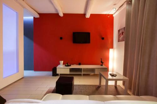 a living room with a red wall with a tv at Villino Erminia - Seaside Art b&b in Pizzo