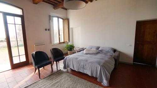 a bedroom with a bed and two chairs and a table at A Casa di Leo in Ravenna