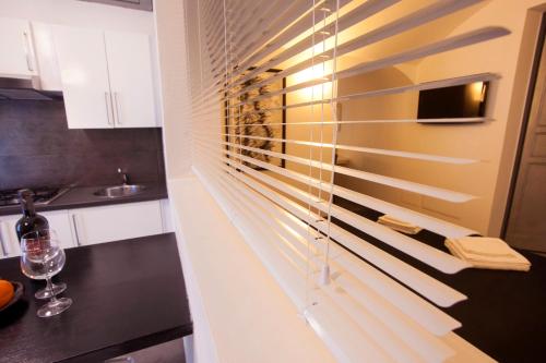 a kitchen with a window with wooden blinds at Villino Erminia - Seaside Art b&b in Pizzo