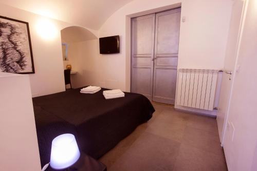 a small bedroom with a black bed and a door at Villino Erminia - Seaside Art b&b in Pizzo
