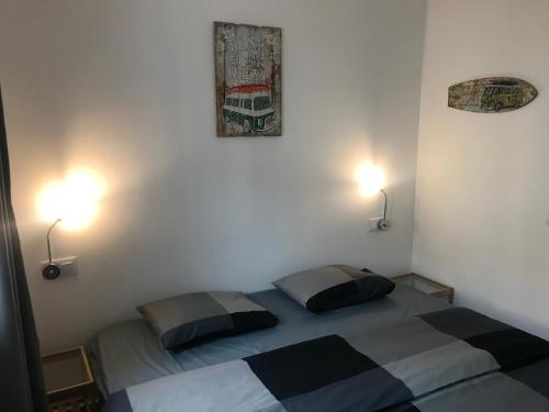 a bedroom with two beds and two lights on the wall at Luxury Apartment in Corralejo