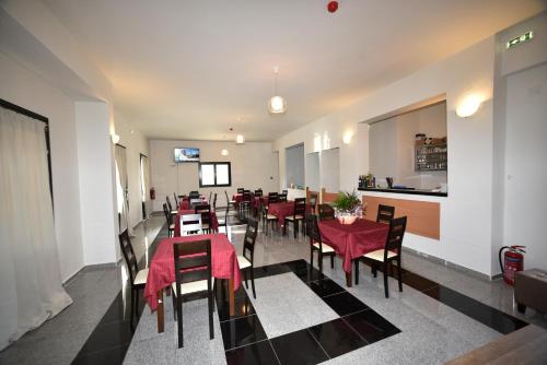 um restaurante com mesas e cadeiras com toalha de mesa vermelha em chalkiotis hotel em Anaxos