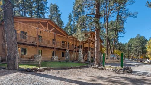 a large log cabin with a wrap around porch at Upper Canyon Inn & Cabins in Ruidoso
