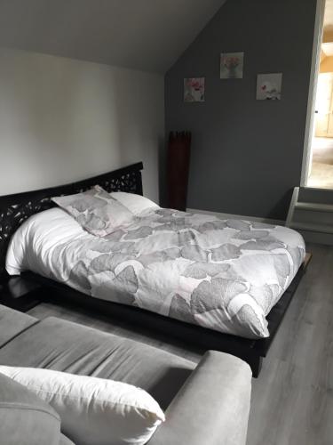 a bedroom with a large bed and a couch at la ville à la campagne in Lisieux