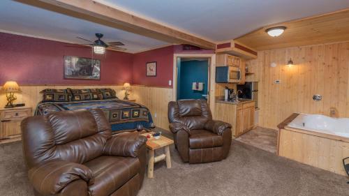 a bedroom with a bed and a couch and a tub at Upper Canyon Inn & Cabins in Ruidoso