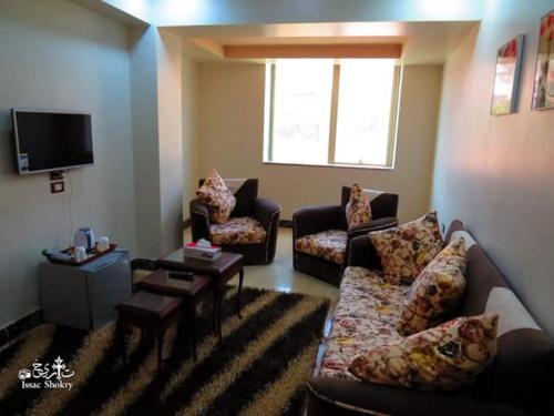 ein Wohnzimmer mit 2 Sofas und einem TV in der Unterkunft St. Marie House in Asyut