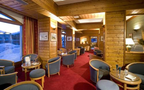 a restaurant with tables and chairs in a train car at Le Calgary in Les Saisies