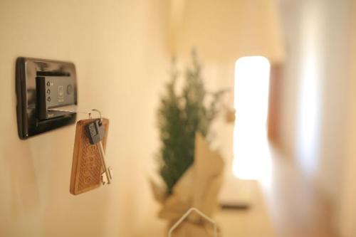 a price tag hanging on a wall with a plant at Le Stanze Di Brando E Nico in Tricase