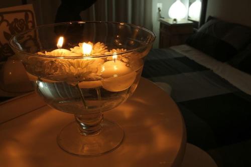a glass vase with candles in it on a table at Le Stanze Di Brando E Nico in Tricase