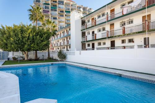 een zwembad voor een gebouw bij Apartamento al lado de la playa in Benalmádena